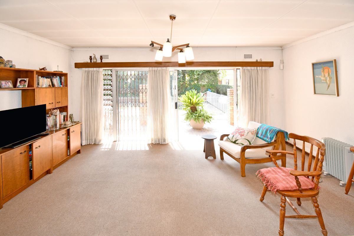 Spacious living room featuring carpeted flooring and large sliding glass doors that provide direct access to the outdoor patio area.