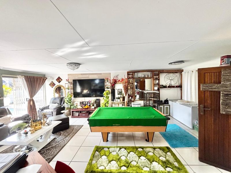 Spacious living area featuring tiled flooring, built-in shelving, and direct access to the outdoor area through sliding glass doors.
