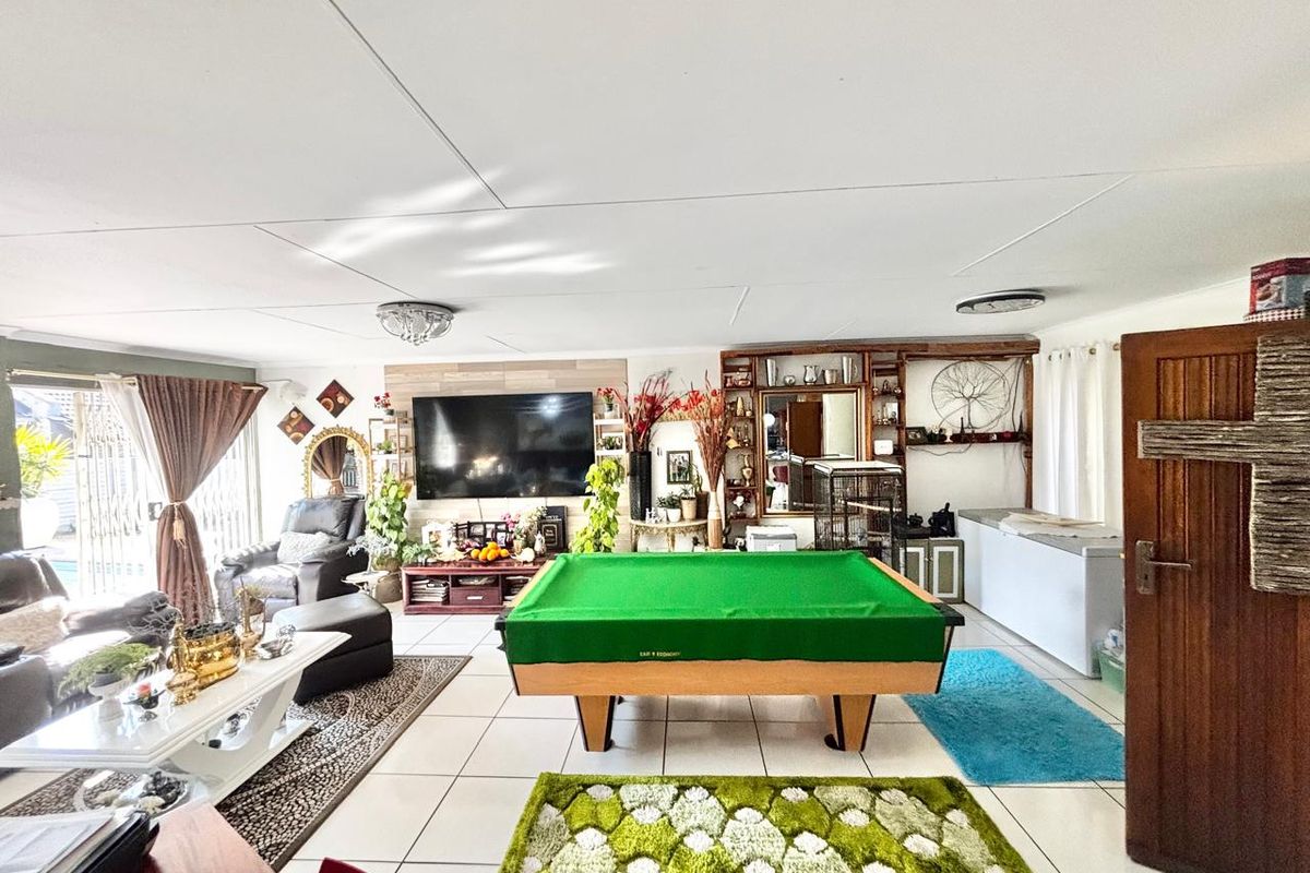 Spacious living area featuring tiled flooring, built-in shelving, and direct access to the outdoor area through sliding glass doors.