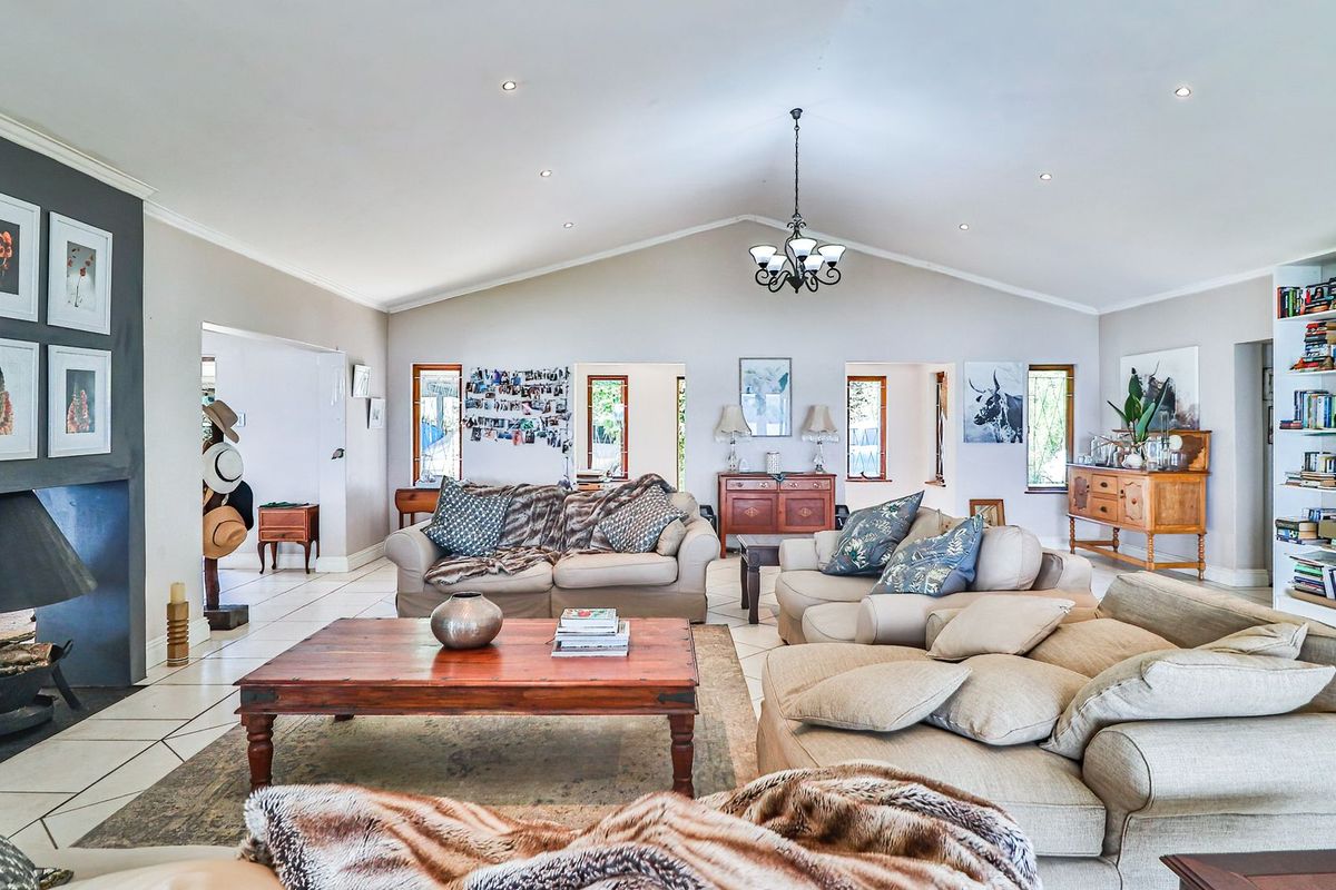 Spacious open-plan living area featuring a vaulted ceiling, recessed lighting, a built-in fireplace, and tiled flooring throughout.