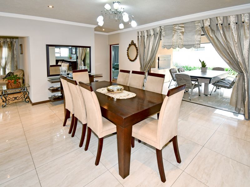 Spacious dining area featuring large format floor tiles, recessed lighting, and seamless access to the outdoor patio through sliding glass doors.