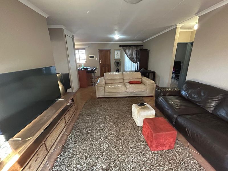 Open-plan living area featuring tiled flooring and a breakfast bar, providing a functional and connected space for daily living.
