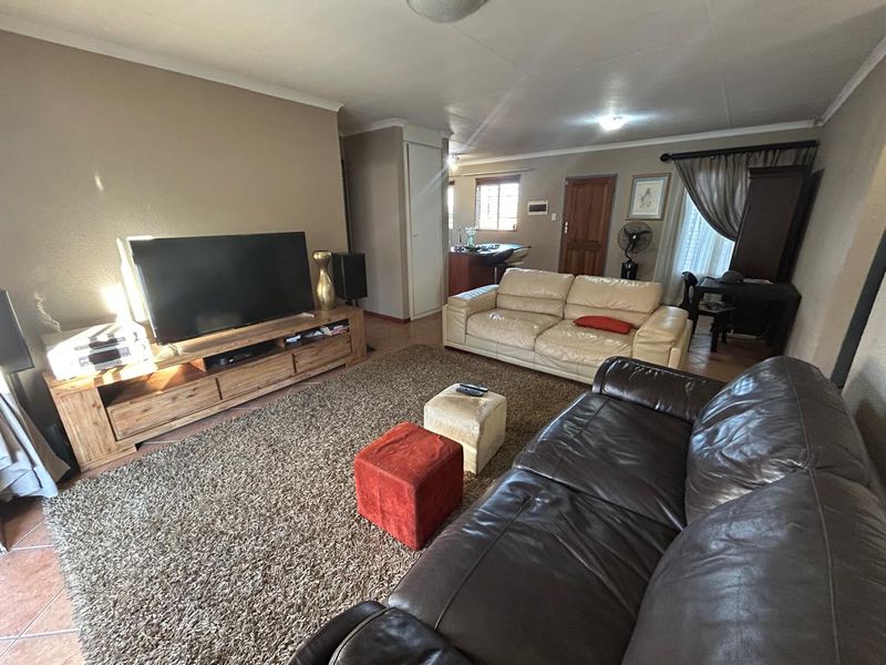 Open plan living area featuring tiled flooring and a connected kitchen space, providing a functional layout for daily living.