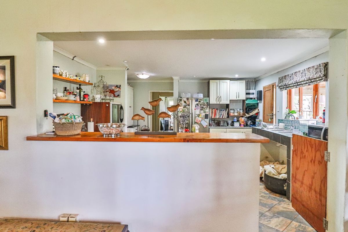 A functional kitchen featuring a breakfast bar, built-in cabinetry, and tiled flooring, offering a practical layout with potential for modern updates.