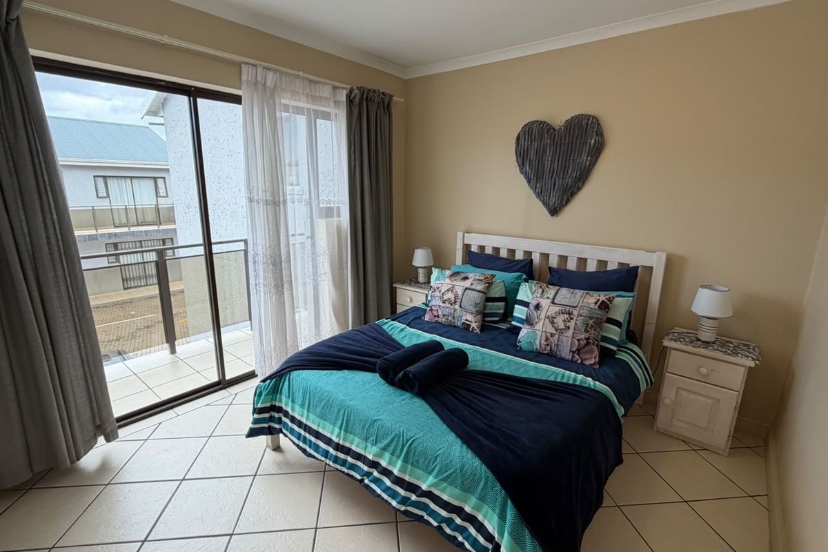 A bedroom featuring tiled flooring and a sliding glass door providing direct access to an outdoor balcony area.
