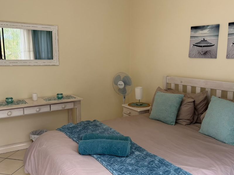 A bedroom featuring neutral wall tones and tiled flooring, providing a functional and comfortable sleeping space.