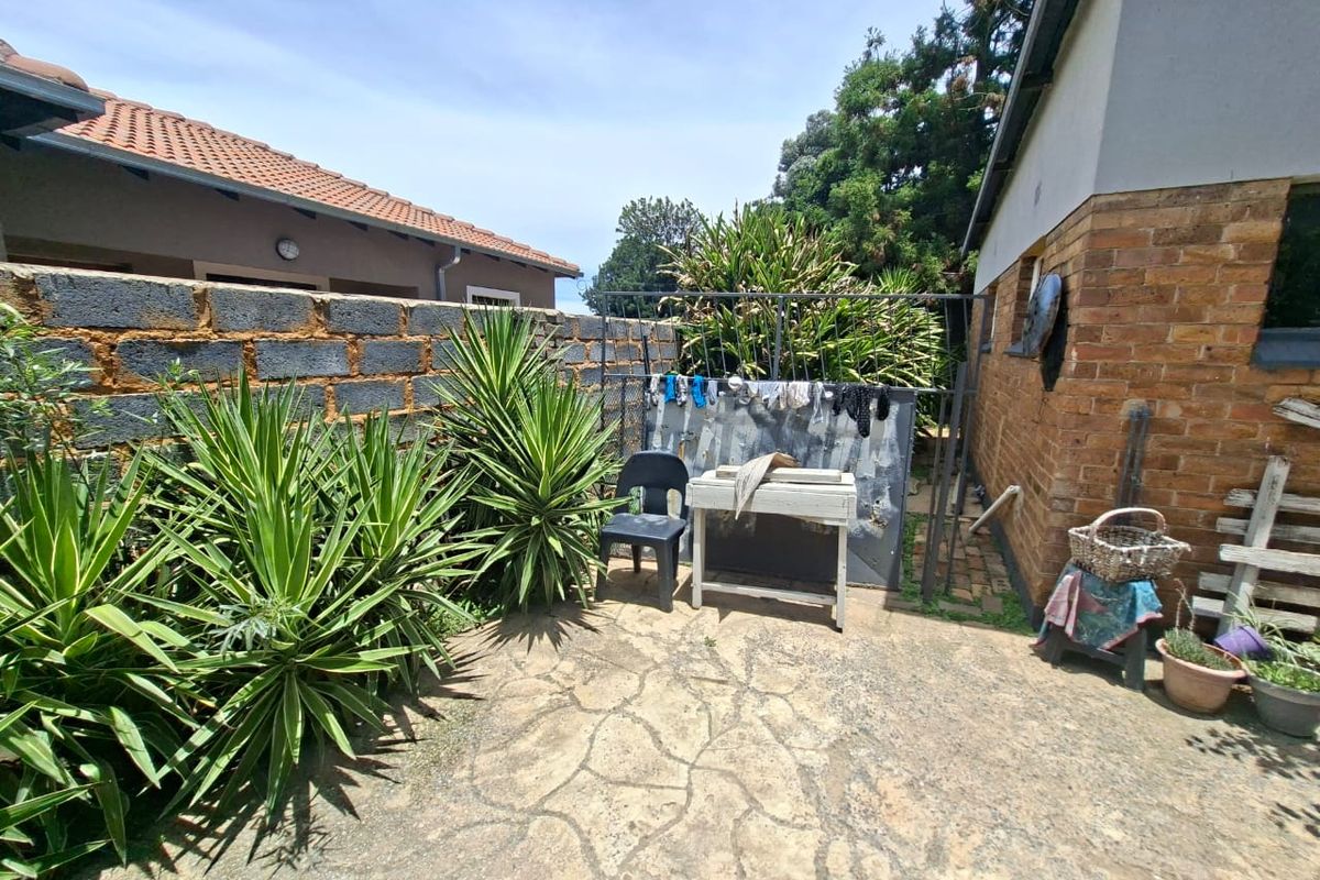 A rear exterior courtyard featuring paved flooring, brick walling, and a concrete block boundary wall, offering potential for outdoor improvement.