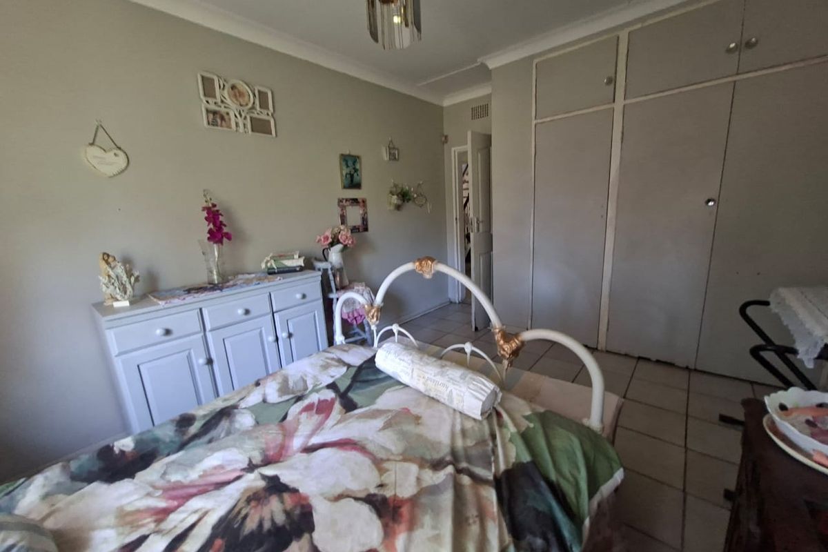 A bedroom featuring tiled flooring and built-in cupboards, providing functional storage space.