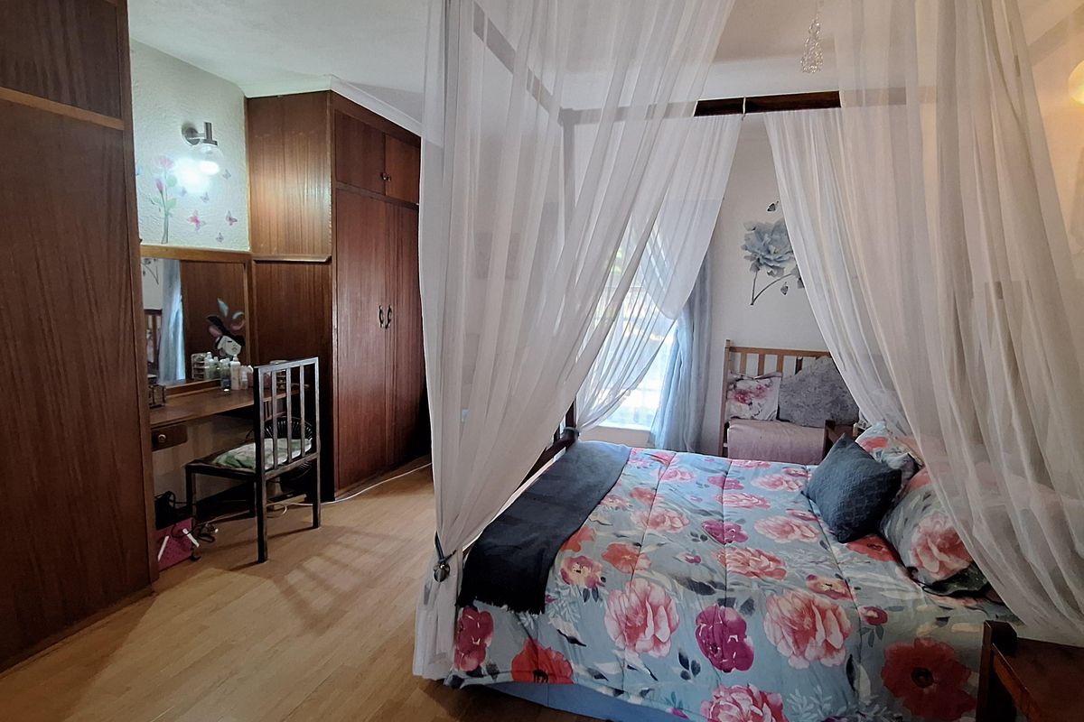 A bedroom featuring built-in wooden wardrobes and a vanity area, providing ample storage space and a functional layout.