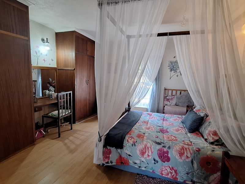 A bedroom featuring built-in wooden wardrobes and a vanity area, providing ample storage space and a functional layout.