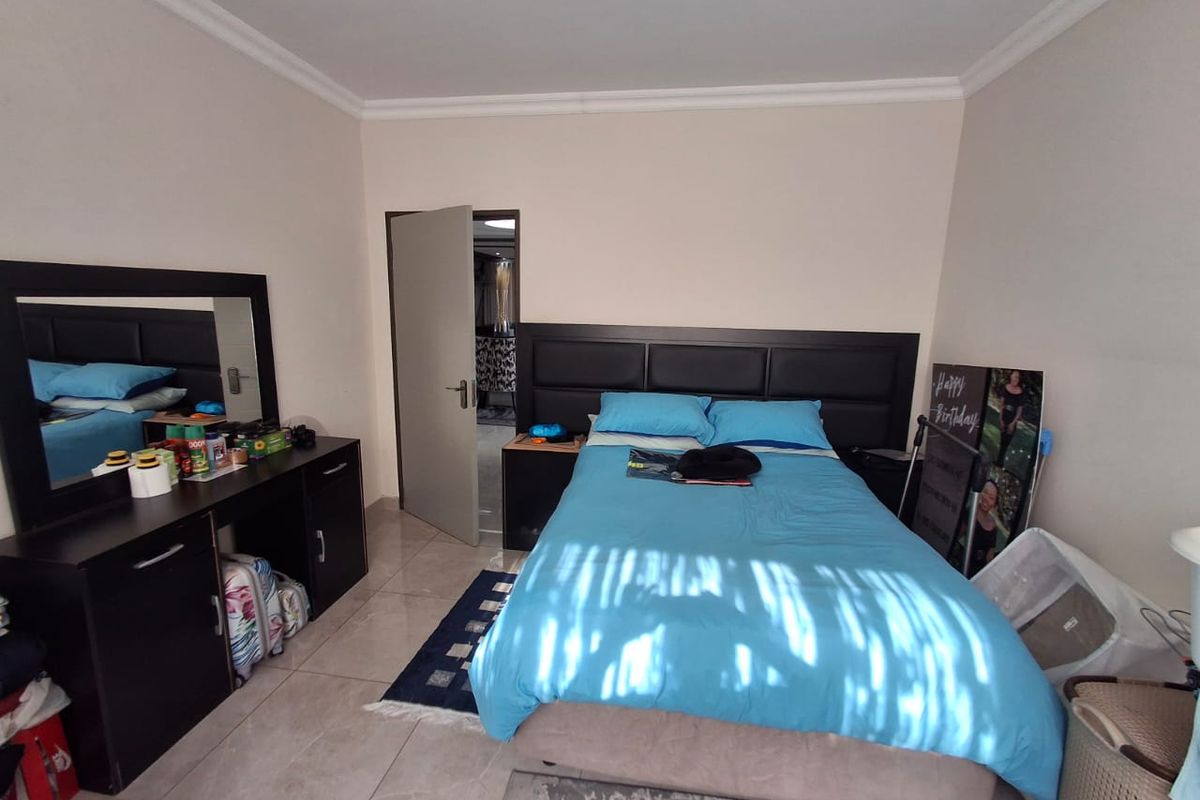 A bedroom featuring tiled flooring and cove cornice detailing, providing a neutral base for personalization.