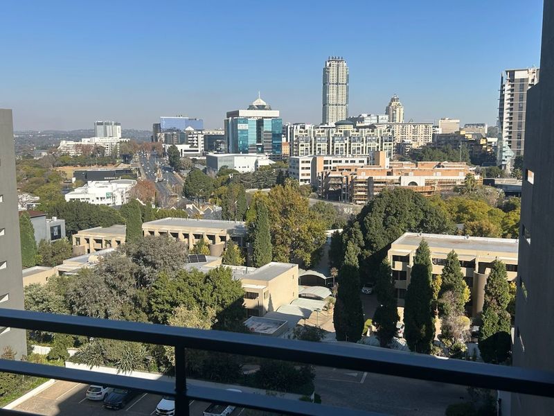 Elevated urban view from a penthouse balcony overlooking the surrounding cityscape and tree-lined neighbourhood.