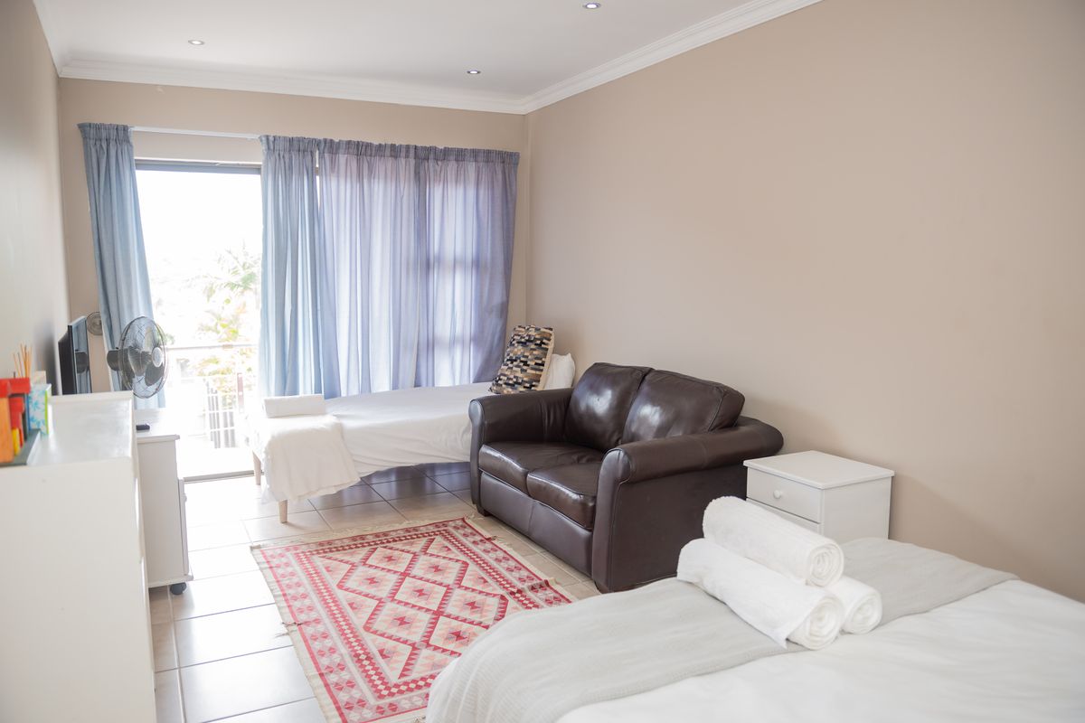 A bedroom featuring tiled flooring, recessed downlights, and a sliding glass door providing access to an outdoor area.