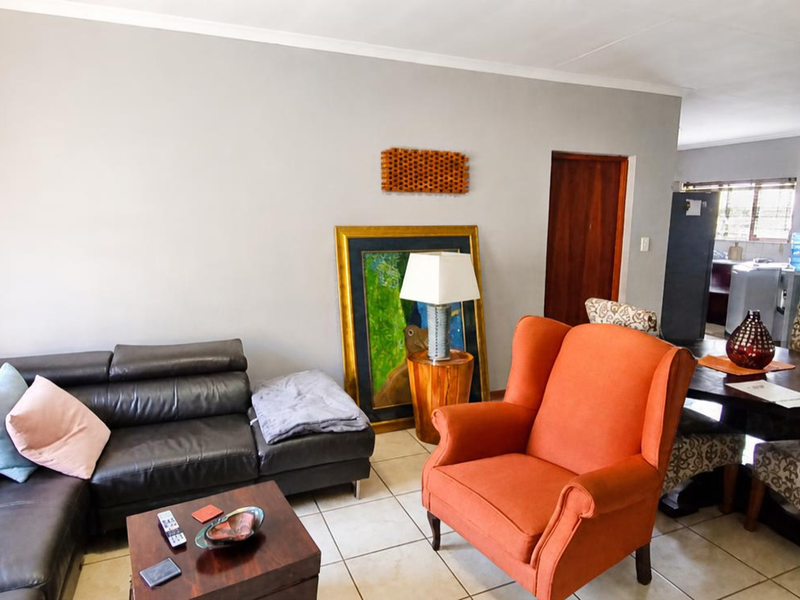 An open-plan living and dining area featuring neutral wall tones and tiled flooring, providing a functional space for relaxation and meals.