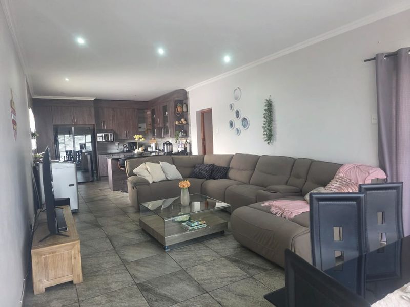 Open plan living area featuring tiled floors, recessed lighting, and a modern kitchen with integrated cabinetry and island.