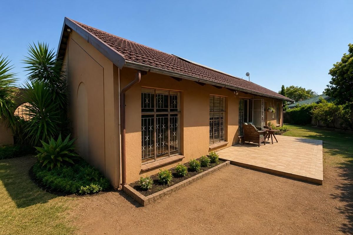 Rear view of the house featuring a tiled patio, established garden, and secure window treatments.