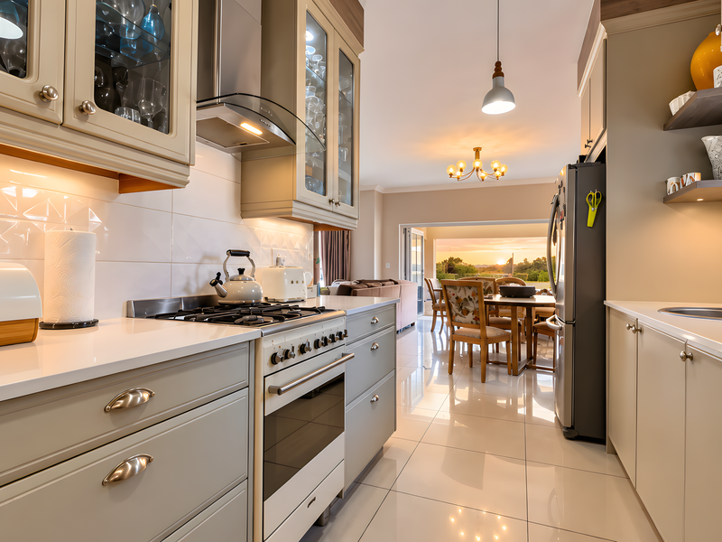 Modern open-plan kitchen featuring high-end cabinetry, quartz countertops, integrated appliances, and polished floor tiles, flowing seamlessly into the dining and living areas.