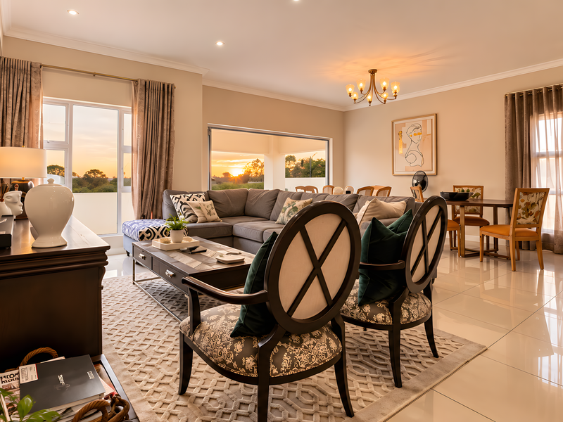Spacious open-plan living and dining area featuring polished tile flooring, modern lighting, and large sliding doors that provide seamless access to the outdoor space.