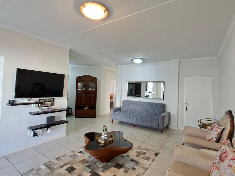 A spacious living room featuring neutral tiled flooring and bright white walls, providing a clean and versatile foundation for your personal style.