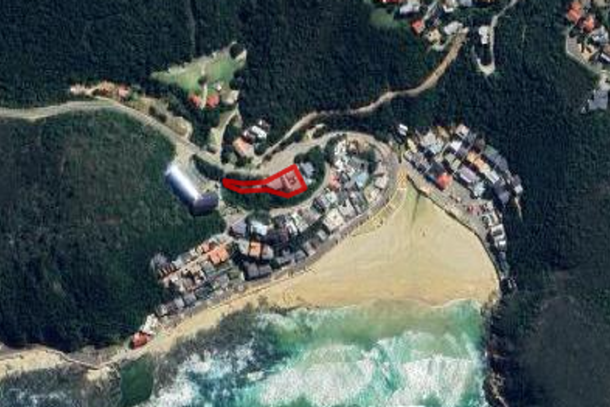Aerial view of the coastal property location, highlighting the site boundaries in relation to the surrounding beach and residential neighborhood.