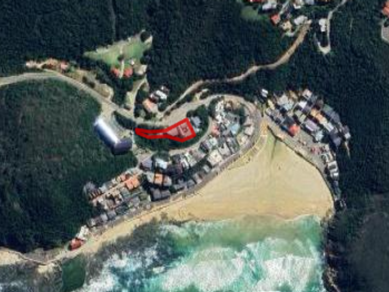 Aerial view of the coastal property location, highlighting the site boundaries in relation to the surrounding beach and residential neighborhood.