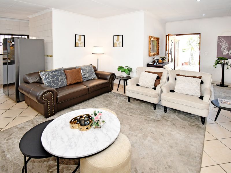 Open-plan living area featuring tiled flooring, recessed lighting, and a seamless transition to the adjacent kitchen space.