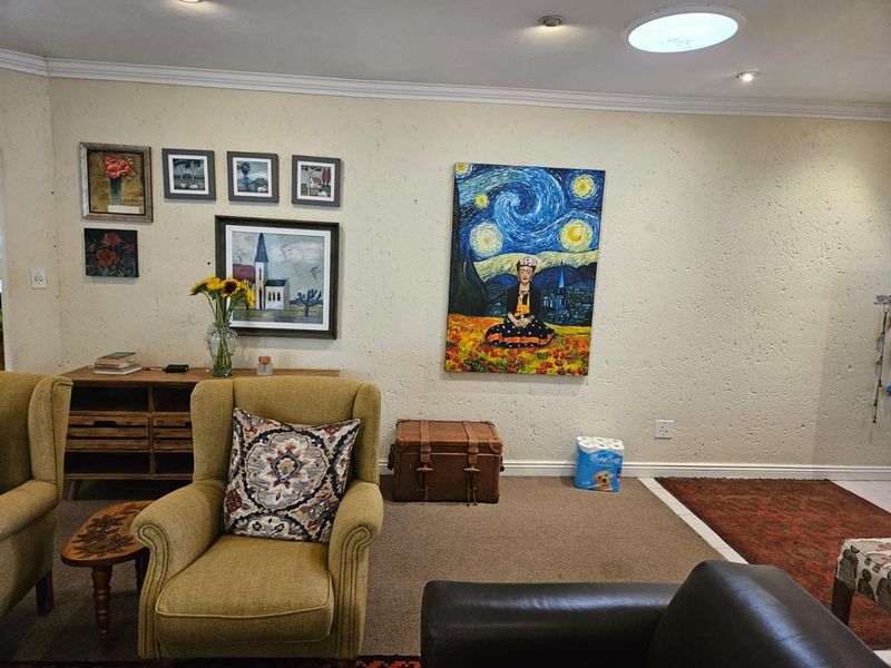 A living room featuring textured walls, coving, and a skylight, providing a neutral base for interior design updates.