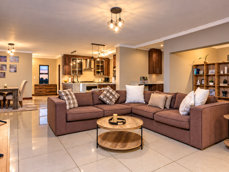 Spacious open-plan living area featuring polished tile floors, a modern kitchen with built-in cabinetry, and a seamless flow between the lounge and dining space.