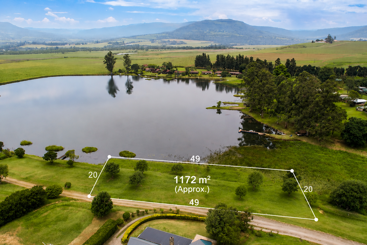 An aerial view of a 1172 square meter vacant residential plot featuring scenic lake frontage and surrounding natural landscape.