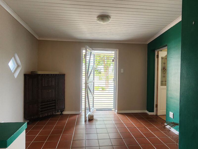 An entrance hall featuring tiled flooring, a security gate, and a tongue and groove ceiling, providing a functional transition space for the home.