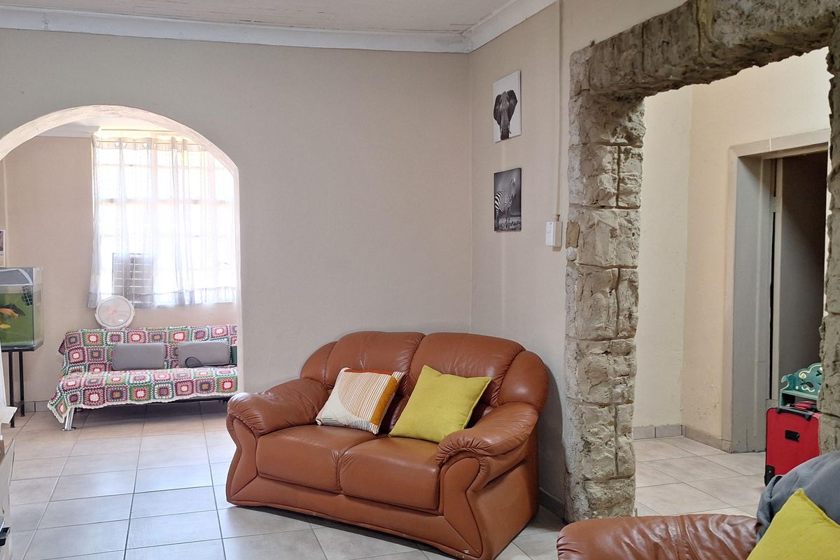 Living area featuring a distinctive stone archway, tiled flooring, and an additional arched alcove space.