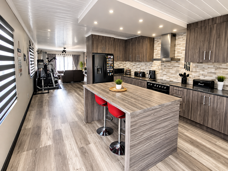 Modern open-plan kitchen featuring wood-grain cabinetry, a central island, stone-look backsplash, and integrated appliances, flowing into a spacious living area.
