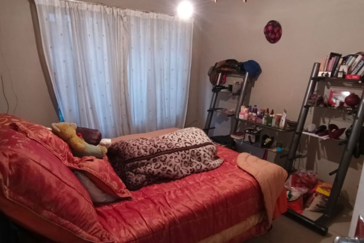 A bedroom featuring a window with curtains and basic electrical fixtures, requiring cosmetic updates to improve the overall finish and presentation.