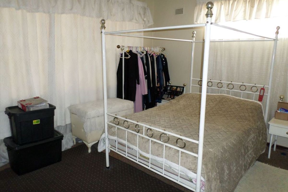 A bedroom featuring carpeted flooring and window treatments, offering a functional space ready for personalization and updates.
