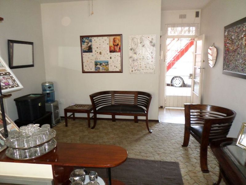 A living room area featuring carpeted flooring and direct access to an exterior entrance with a security gate.
