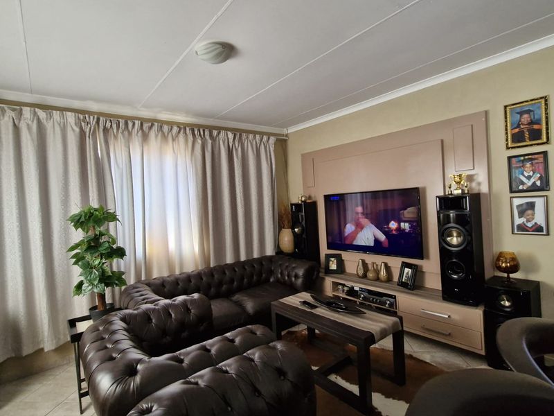 A comfortable living room featuring tiled flooring and a custom built-in media wall unit for entertainment.
