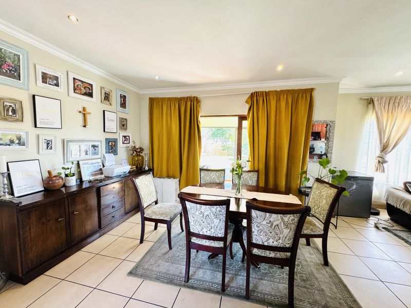 A bright dining room featuring tiled flooring, recessed lighting, and built-in cabinetry, with direct access to the outdoor area through a sliding glass door.