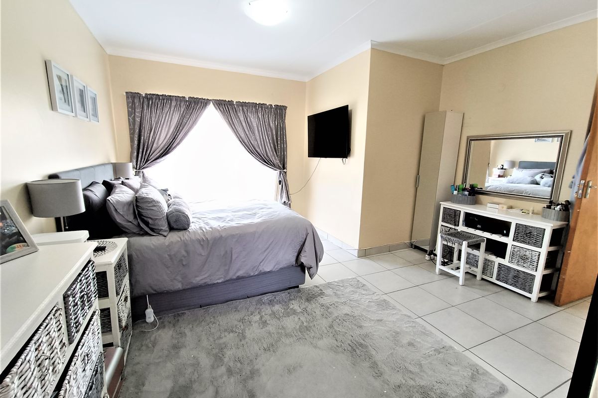 A bedroom featuring tiled flooring and neutral wall finishes, providing a functional space with natural light.