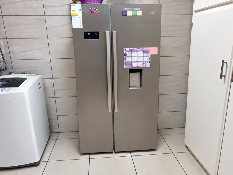 A functional laundry area featuring tiled walls, tiled flooring, and built-in storage cabinetry.