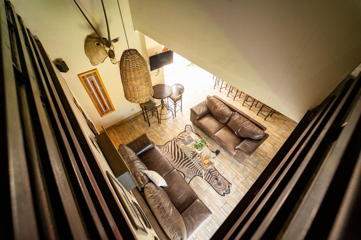 An elevated view of a spacious living area featuring tiled flooring, high vaulted ceilings, and a warm, inviting atmosphere.