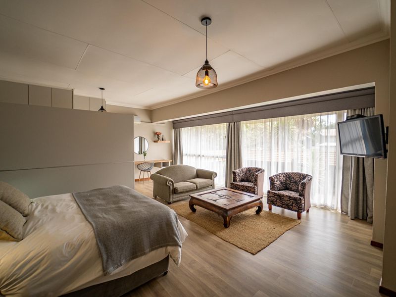 Spacious bedroom featuring modern laminate flooring, built-in cabinetry, and large sliding glass doors that provide ample natural light.