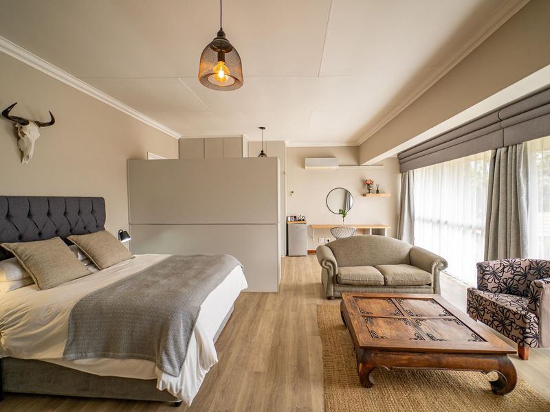 Spacious bedroom suite featuring modern laminate flooring, a built-in partition wall, integrated desk area, and split-system air conditioning for climate control.