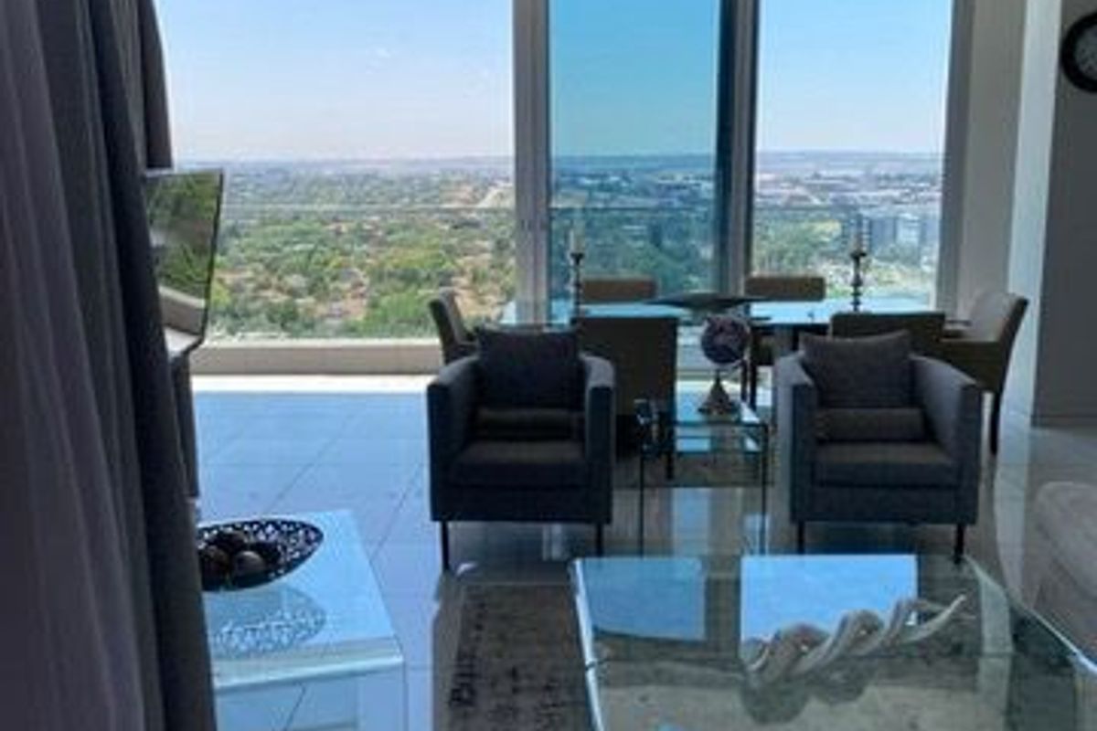 Spacious open-plan living area featuring floor-to-ceiling glass doors that provide expansive panoramic views and abundant natural light.