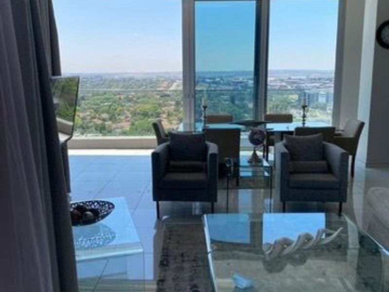 Spacious open-plan living area featuring floor-to-ceiling glass doors that provide expansive panoramic views and abundant natural light.