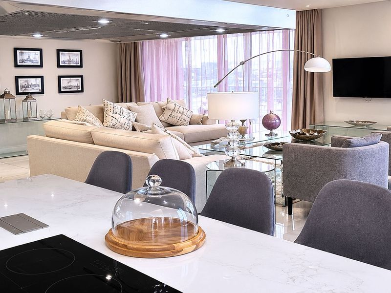 Spacious open-plan living area featuring a modern kitchen island with integrated hob, high-end finishes, and seamless flow to the lounge space.