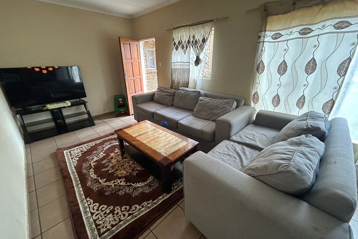 A functional living room featuring tiled flooring and direct access to an exterior entrance.