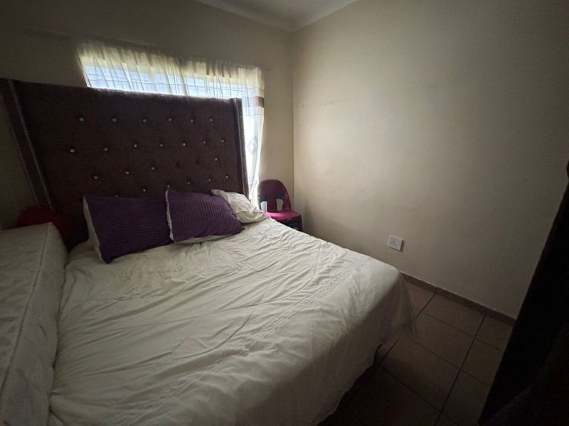 A standard bedroom featuring tiled flooring and neutral wall finishes, providing a functional space for rest.