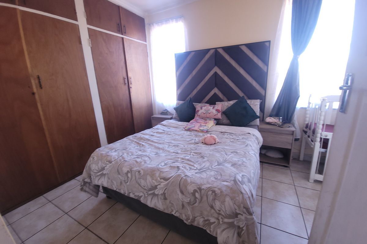 A bedroom featuring built-in wooden cupboards and tiled flooring, providing functional storage and a neutral base for interior design.