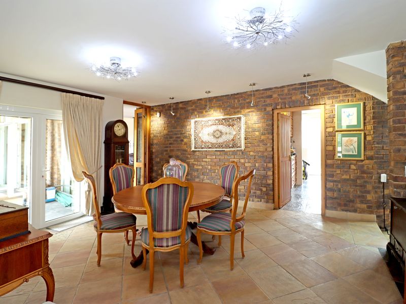 Dining room featuring exposed brick walls, stone tile flooring, and glass sliding doors providing access to the outdoor area.