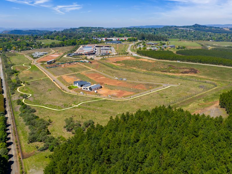 An aerial view of a developing residential estate featuring paved roads, established infrastructure, and surrounding natural landscape.